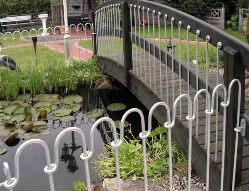 Eine Brücke über einen Gartenteich kindersicher schützen.