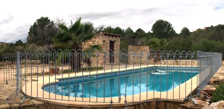 Verzinkter Pool-Stellzaun mit Standfüßen vor einem Schwimmbad auf Mallorca