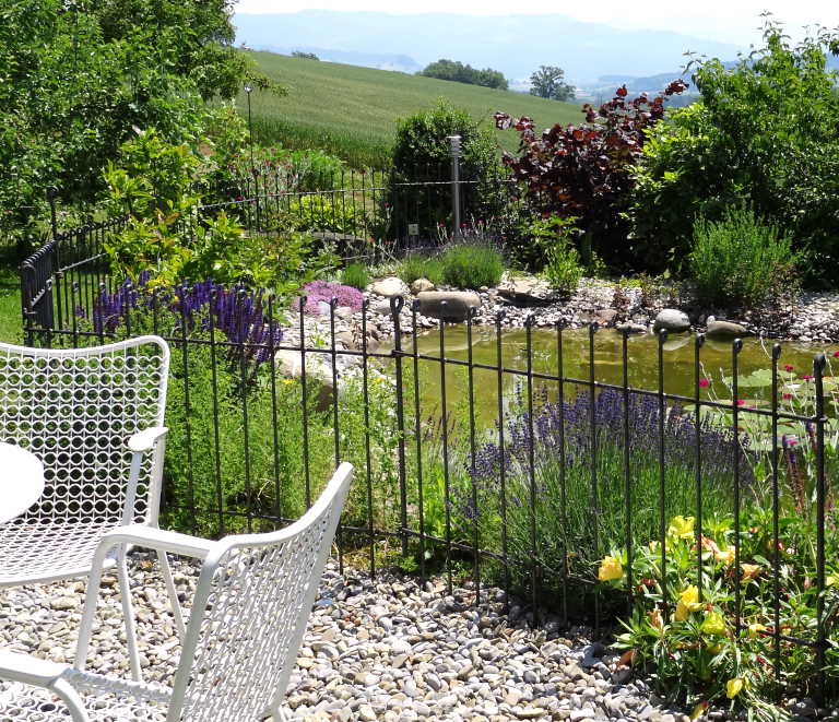 Der Gartenteich wird mit Garten Zaun sicher von der Terrasse abgetrennt