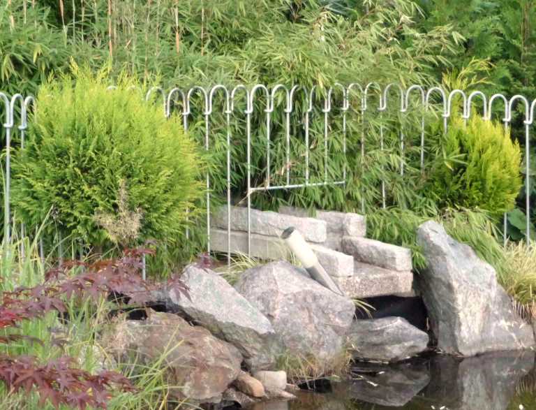 Gartenteichzaun mit integriertem Bachlaufelement als Teichschutz.
