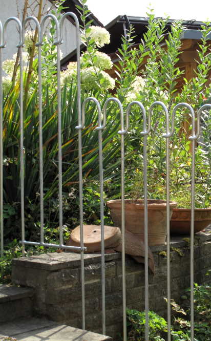 Ein Bachlaufelement des Schutzzaun um eine Gartenmauer zu überbrücken.