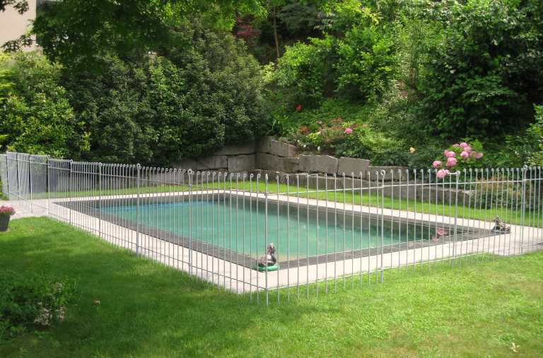 Garten-Steck-Zaun im Rasen montiert, sichert den Schwimmbad Bereich im Garten