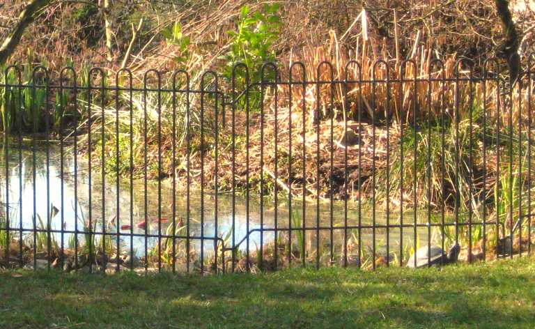 mobiler Schildkröten-Zaun vor einem Zierteich im Garten